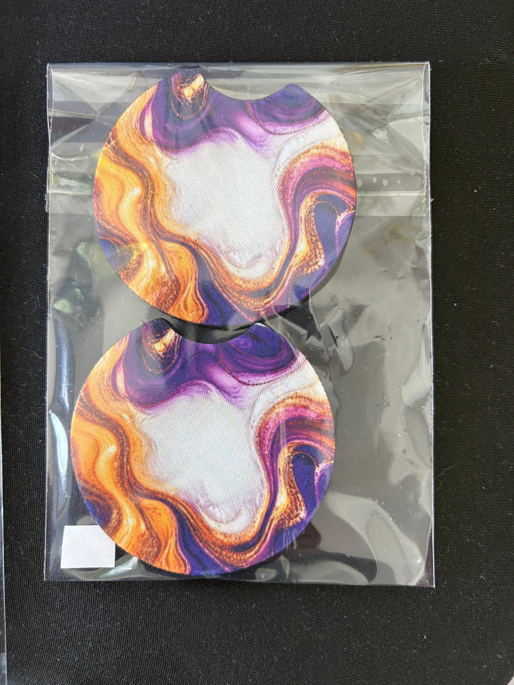 Pair of purple, gold and white marbled car coasters in packaging